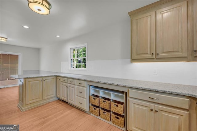 kitchen featuring light wood-type flooring, a peninsula, light brown cabinetry, and recessed lighting