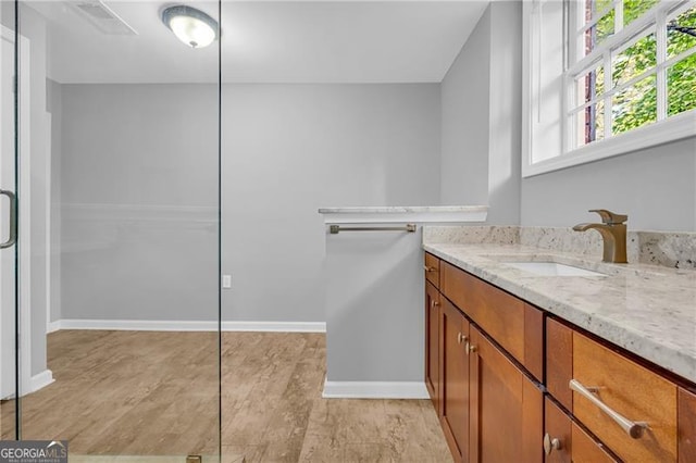 bathroom with vanity, baseboards, and wood finished floors