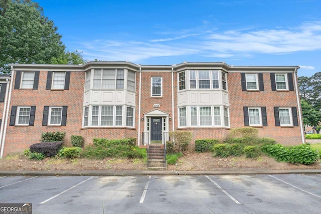 multi unit property with uncovered parking and brick siding