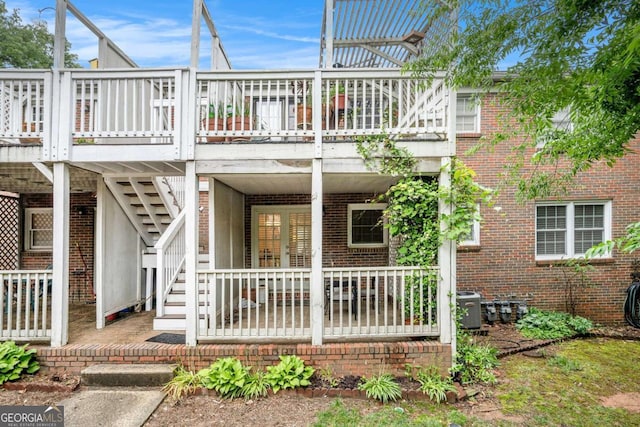 back of house with brick siding, a wooden deck, central AC unit, and stairway