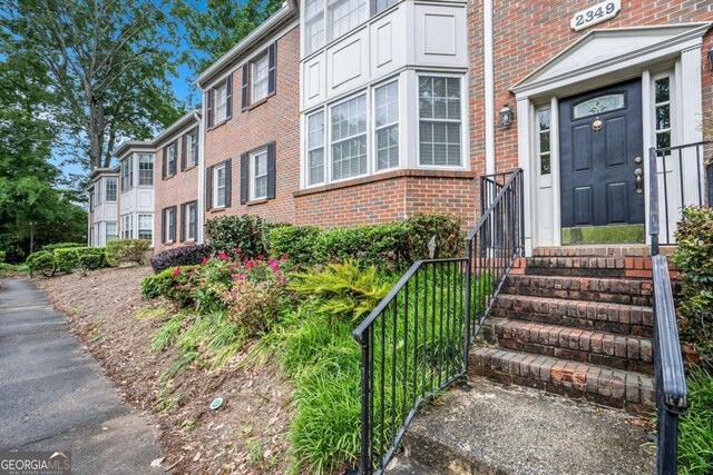 view of exterior entry featuring brick siding