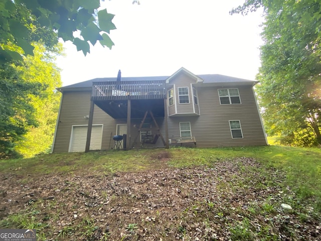 rear view of house with a deck and a garage