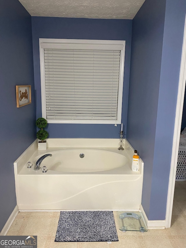 565 Miles Ct, Locust Grove, GA 30248 - bathroom featuring a garden tub and baseboards