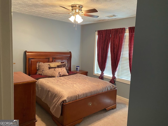 bedroom featuring carpet floors, a ceiling fan, baseboards, and a textured ceiling