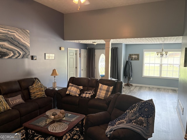 565 Miles Ct, Locust Grove, GA 30248 - living room featuring wood finished floors, a towering ceiling, decorative columns, baseboards, and ceiling fan