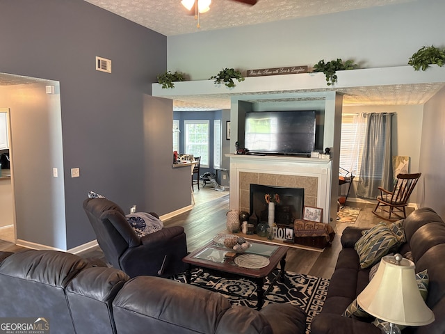 565 Miles Ct, Locust Grove, GA 30248 - living room featuring wood finished floors, a textured ceiling, ceiling fan, baseboards, and a fireplace