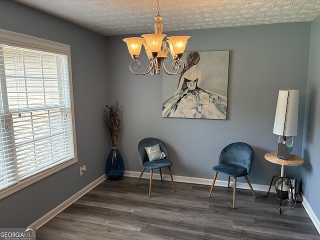 565 Miles Ct, Locust Grove, GA 30248 - sitting room featuring plenty of natural light, a chandelier, wood finished floors, and baseboards