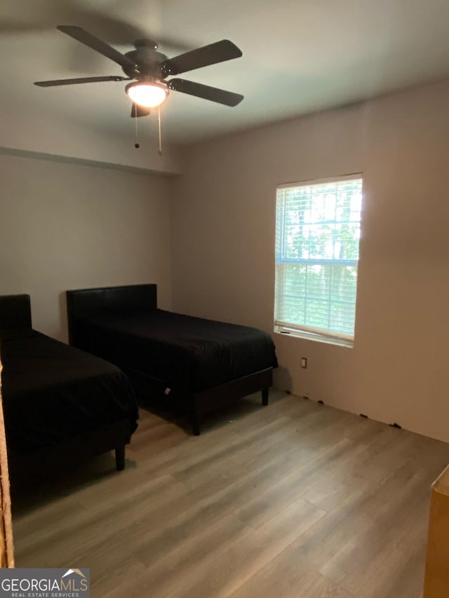 bedroom with light wood-type flooring and a ceiling fan