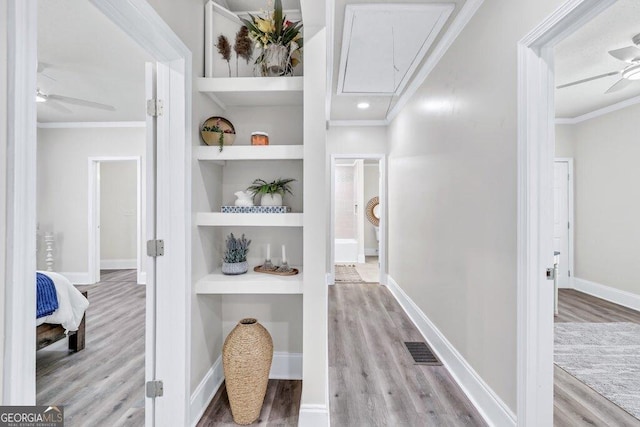 11 Poplar St, Porterdale, GA 30014 - corridor featuring attic access, wood finished floors, crown molding, built in shelves, and baseboards
