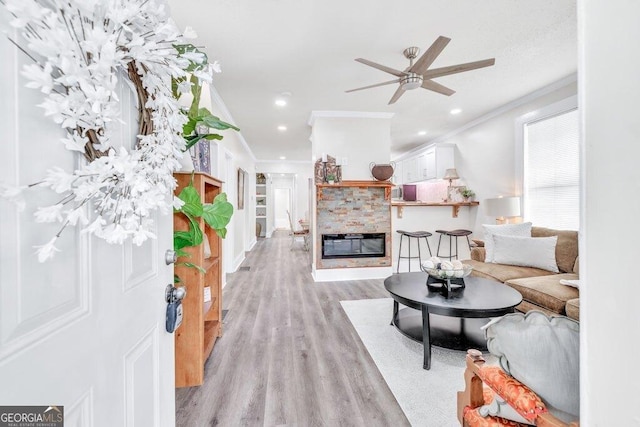 11 Poplar St, Porterdale, GA 30014 - living area featuring crown molding, light wood-style flooring, ceiling fan, a glass covered fireplace, and recessed lighting