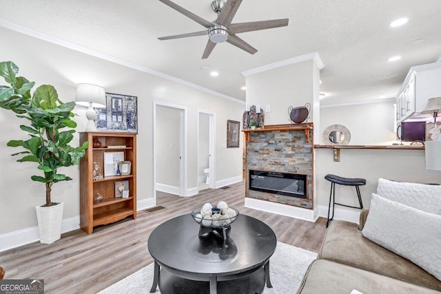 11 Poplar St, Porterdale, GA 30014 - living room with a stone fireplace, a ceiling fan, light wood finished floors, ornamental molding, and baseboards