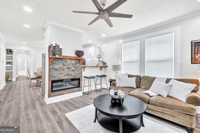 11 Poplar St, Porterdale, GA 30014 - living room with crown molding, ceiling fan, light wood-type flooring, recessed lighting, and a fireplace