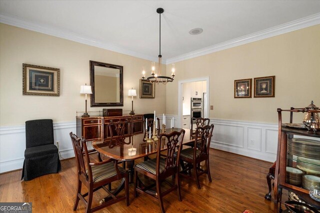 1681 Wild Azalea Ln, Athens, GA 30606 - dining area featuring a chandelier, wood finished floors, wainscoting, crown molding, and a decorative wall