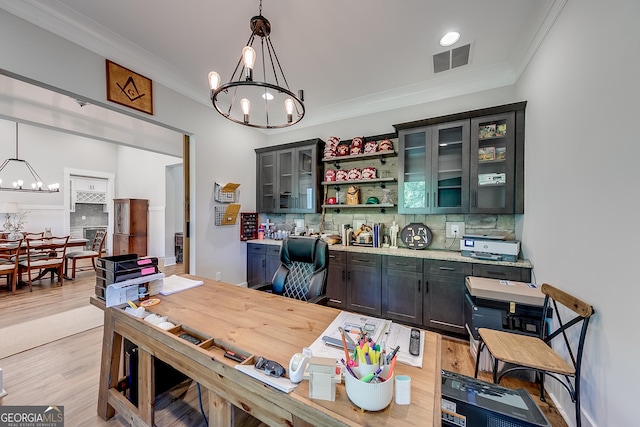 dining space with a chandelier, crown molding, and light wood-style flooring
