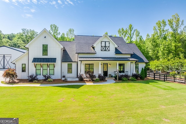back of property with a standing seam roof, board and batten siding, a porch, a shingled roof, and metal roof