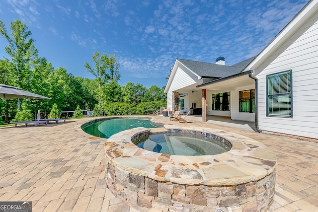 view of swimming pool featuring a patio, a pool with connected hot tub, and ceiling fan