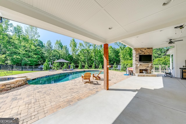 view of swimming pool with an outdoor stone fireplace, a patio area, a fenced backyard, and view of wooded area