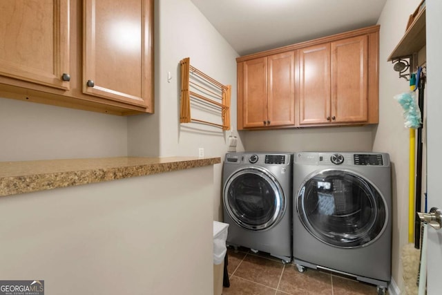 laundry room featuring cabinet space, washing machine and dryer, and tile patterned floors