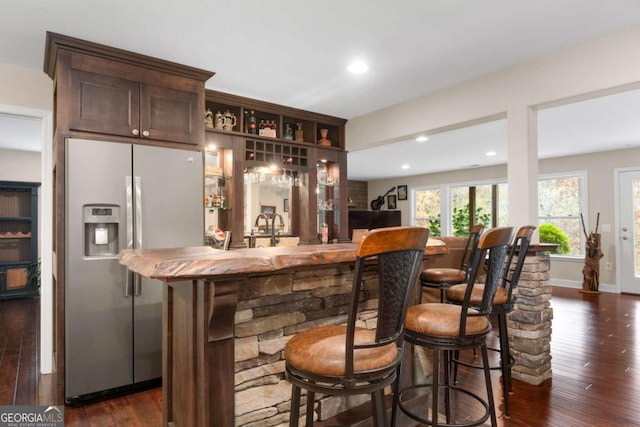 indoor wet bar featuring stainless steel fridge with ice dispenser, dark wood-style flooring, and recessed lighting