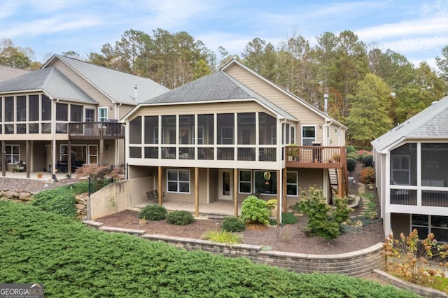 back of property featuring a sunroom, stairway, a patio, and a deck