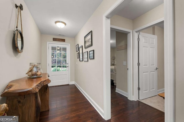 hallway featuring hardwood / wood-style flooring and baseboards