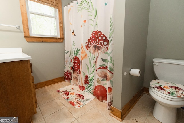 bathroom featuring toilet, tile patterned flooring, vanity, baseboards, and a shower with curtain