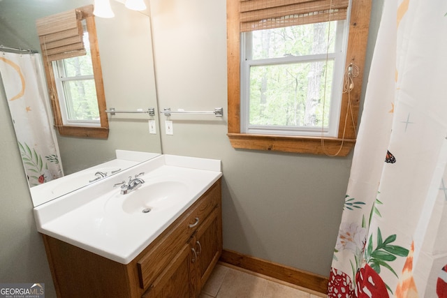 bathroom with baseboards, vanity, and tile patterned flooring