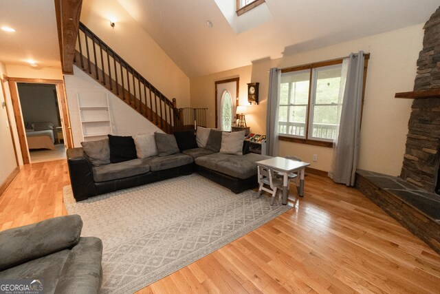 living room featuring wood finished floors, stairway, a skylight, recessed lighting, and baseboards