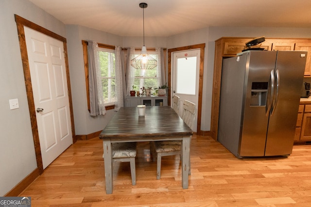 dining room featuring light wood finished floors and baseboards