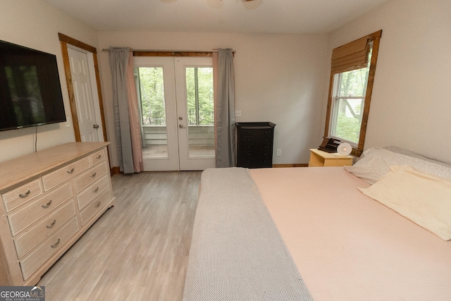 bedroom with french doors, access to outside, and light wood-style flooring