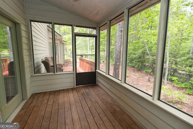 unfurnished sunroom featuring lofted ceiling and plenty of natural light