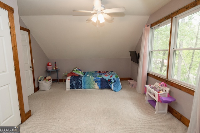 carpeted bedroom with vaulted ceiling, multiple windows, baseboards, and a ceiling fan