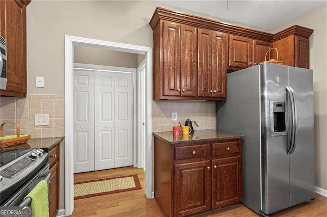 226 Hames Rd Unit 335, Woodstock, GA 30188 - kitchen with stainless steel refrigerator with ice dispenser, stove, light wood finished floors, and decorative backsplash