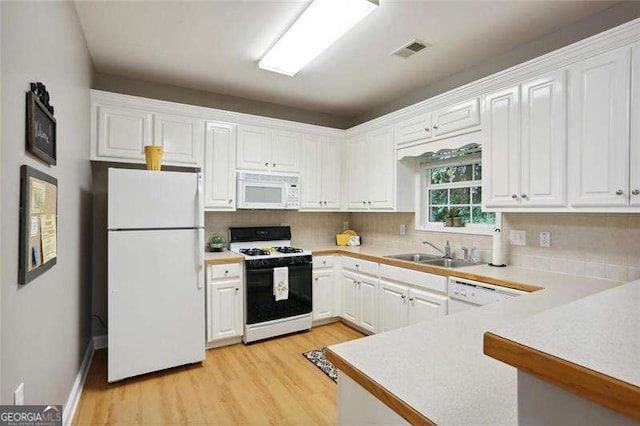 226 Hames Rd Unit 335, Woodstock, GA 30188 - kitchen featuring white appliances, light wood-style flooring, white cabinets, decorative backsplash, and light countertops