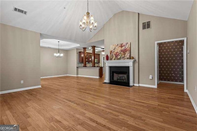 226 Hames Rd Unit 335, Woodstock, GA 30188 - unfurnished living room with a chandelier, wood finished floors, a fireplace, and high vaulted ceiling