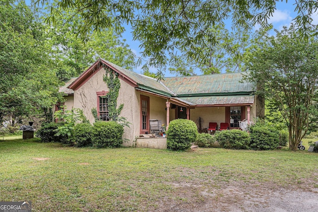 2249 Jackson Lake Rd, Mansfield, GA 30055 - view of front of house with a front yard, stucco siding, metal roof, and covered porch