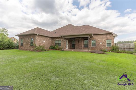 rear view of house with brick siding and a patio