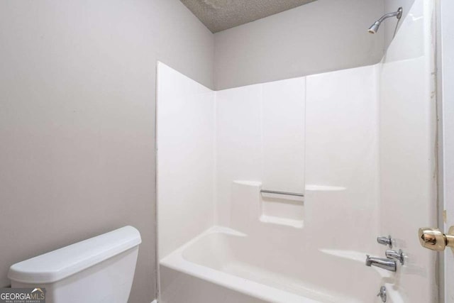full bath featuring toilet,  shower combination, and a textured ceiling
