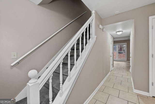 staircase featuring baseboards and tile patterned flooring