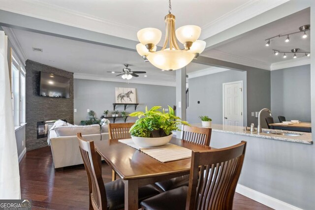 dining area with a fireplace, ceiling fan, dark wood-style floors, a chandelier, and ornamental molding