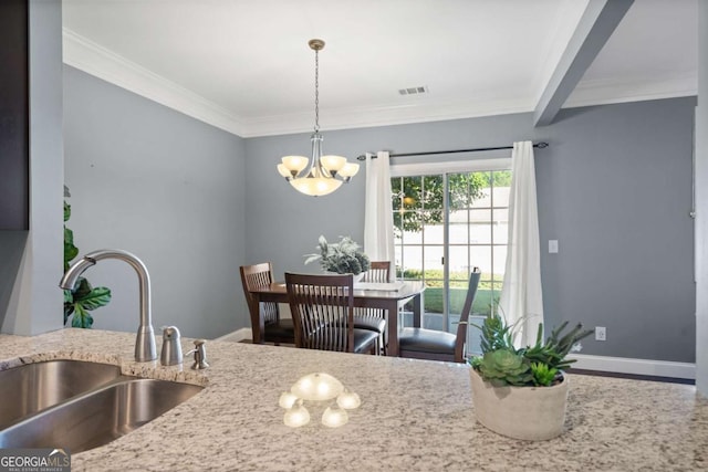dining space featuring a chandelier, ornamental molding, and baseboards