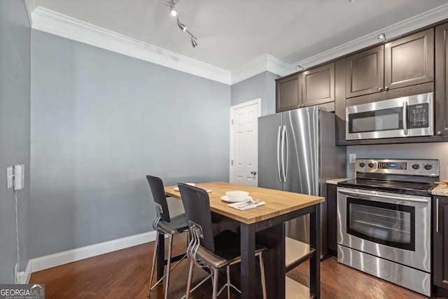 kitchen with appliances with stainless steel finishes, ornamental molding, wooden counters, dark wood-type flooring, and dark brown cabinetry