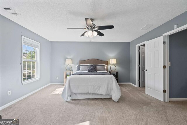 carpeted bedroom featuring a textured ceiling, ceiling fan, and baseboards