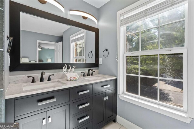 full bathroom with double vanity, ceiling fan, and tile patterned floors