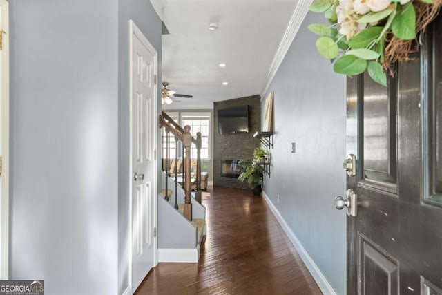 entryway with stairs, crown molding, baseboards, wood finished floors, and a multi sided fireplace