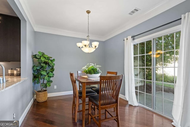 dining space with wood finished floors, ornamental molding, a chandelier, and baseboards
