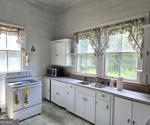 61 Calhoun St, Gibson, GA 30810 - kitchen featuring white electric range, stainless steel microwave, a sink, light countertops, and white cabinets