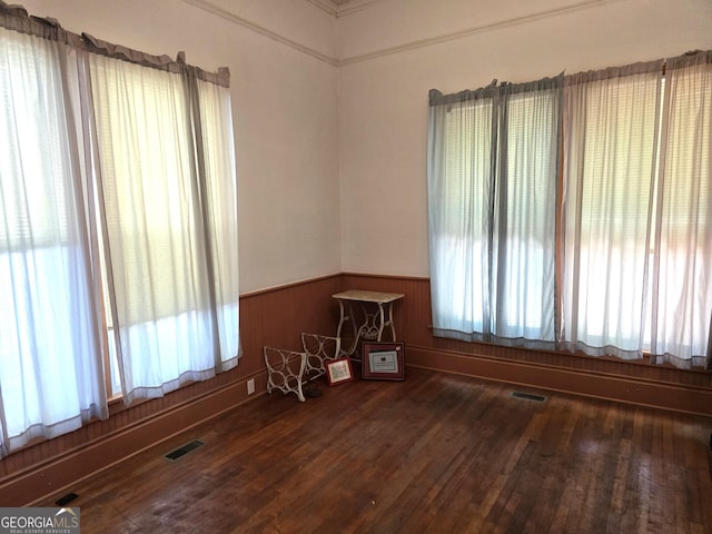 61 Calhoun St, Gibson, GA 30810 - empty room featuring healthy amount of natural light, a wainscoted wall, and wood finished floors