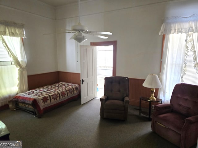 61 Calhoun St, Gibson, GA 30810 - carpeted bedroom featuring wainscoting, wood walls, and a ceiling fan