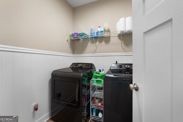 washroom featuring washer and dryer and wainscoting